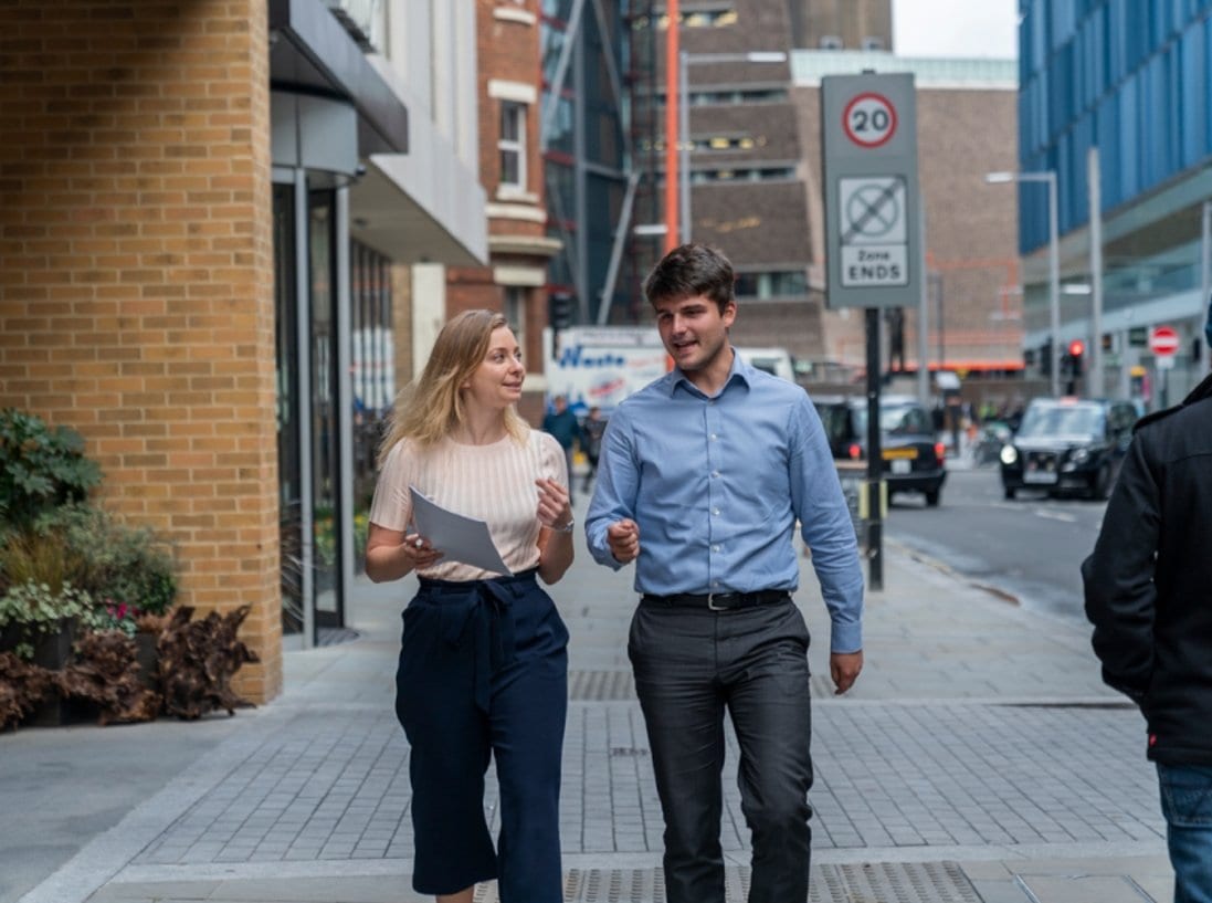 Two professionals walking down a road having a conversation